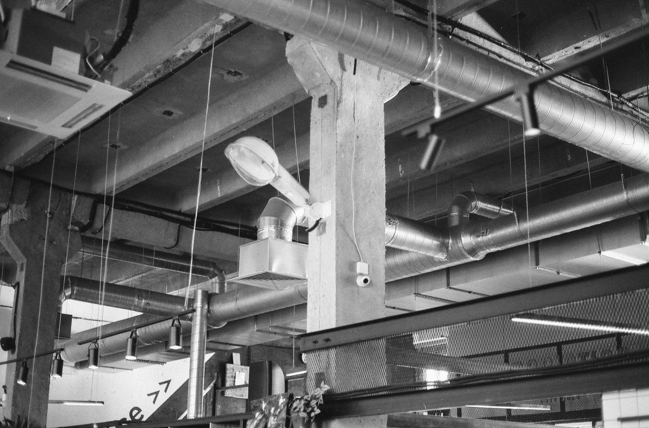 Black and white photo of industrial interior with exposed ducts and pipes in Saint Petersburg.