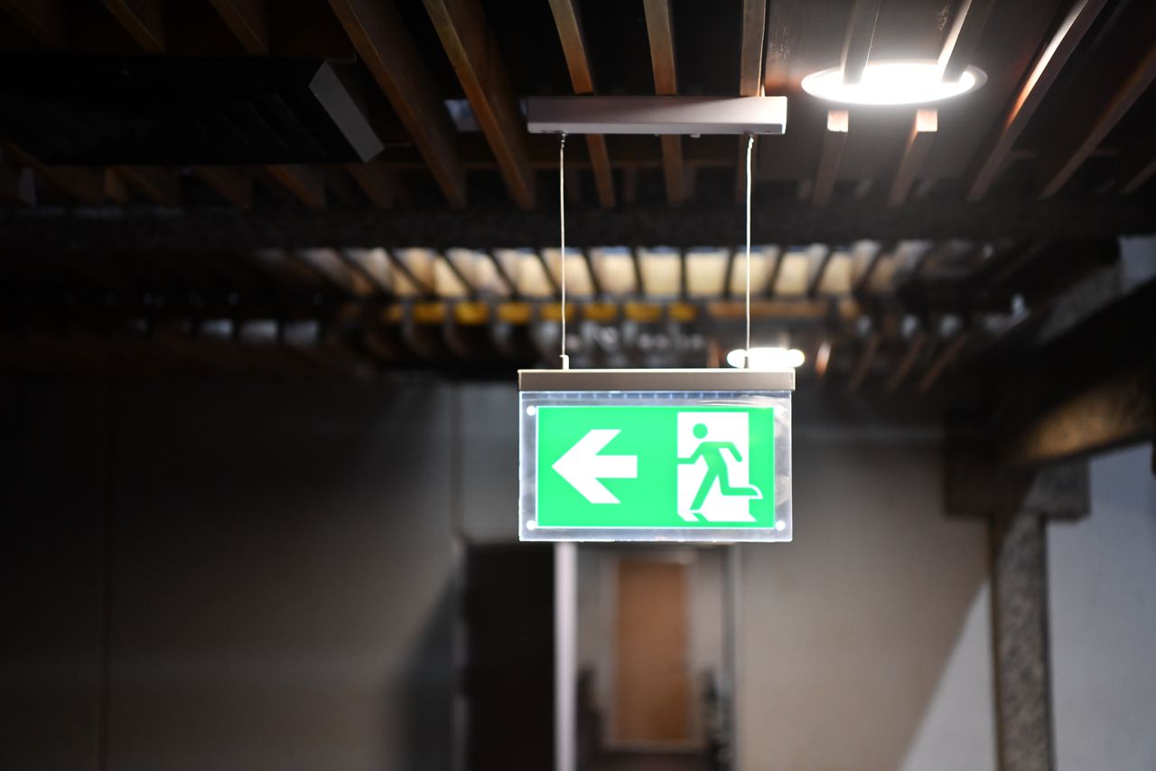 Green emergency exit sign with arrow and running figure indoors in Nairobi conference center.