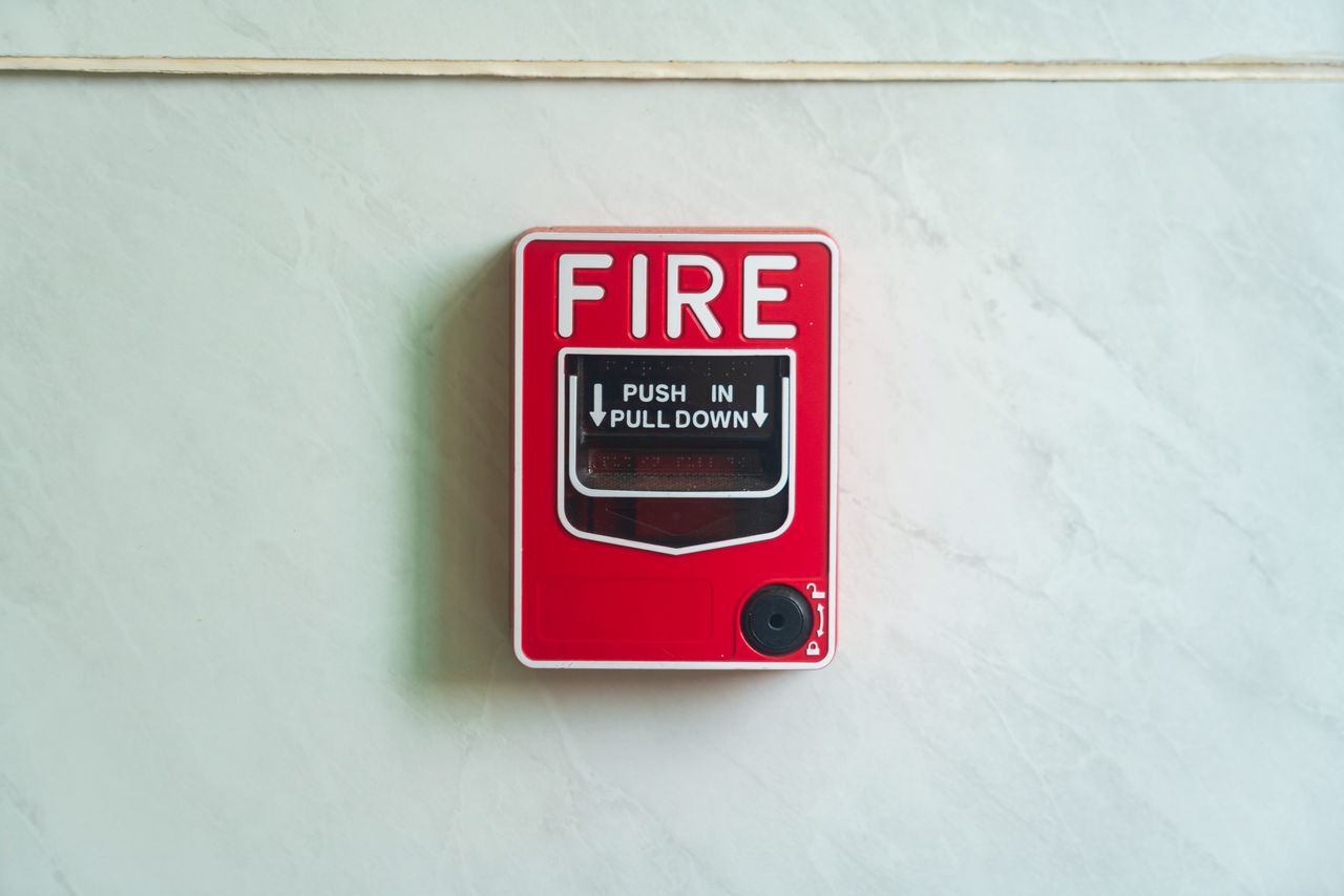 Image of a wall mounted red fire alarm device for safety alerts and emergency preparedness.